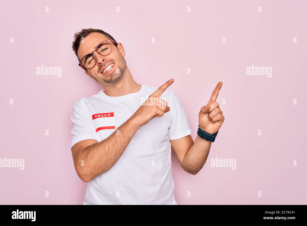 Handsome man with blue eyes wearing sticker with hello my name is ...