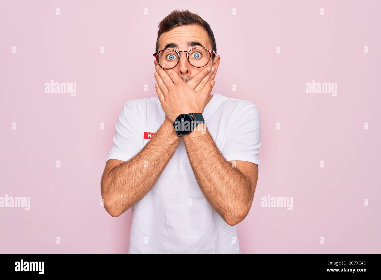 Handsome man with blue eyes wearing sticker with hello my name is ...
