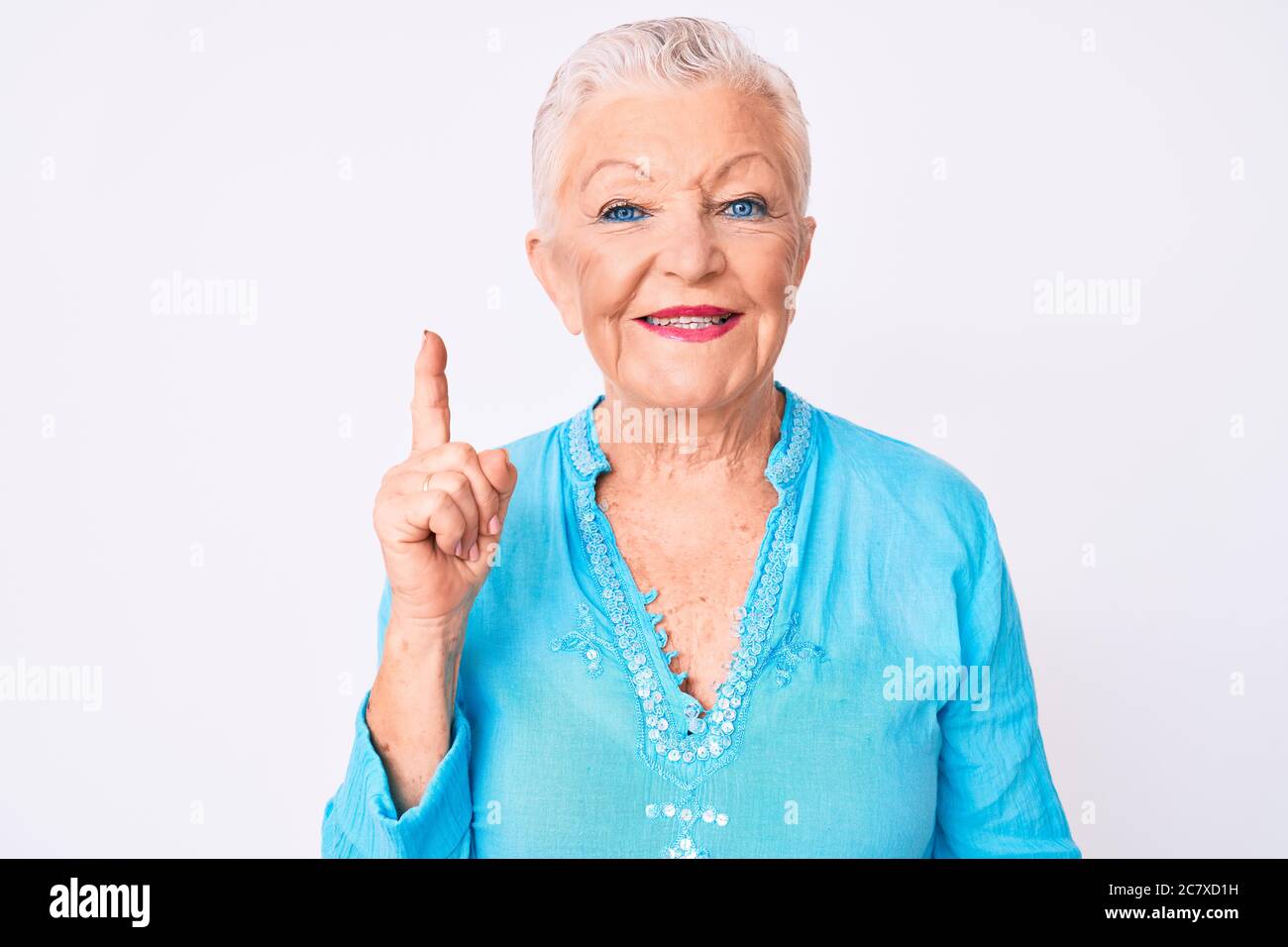 Senior beautiful woman with blue eyes and grey hair wearing summer ...