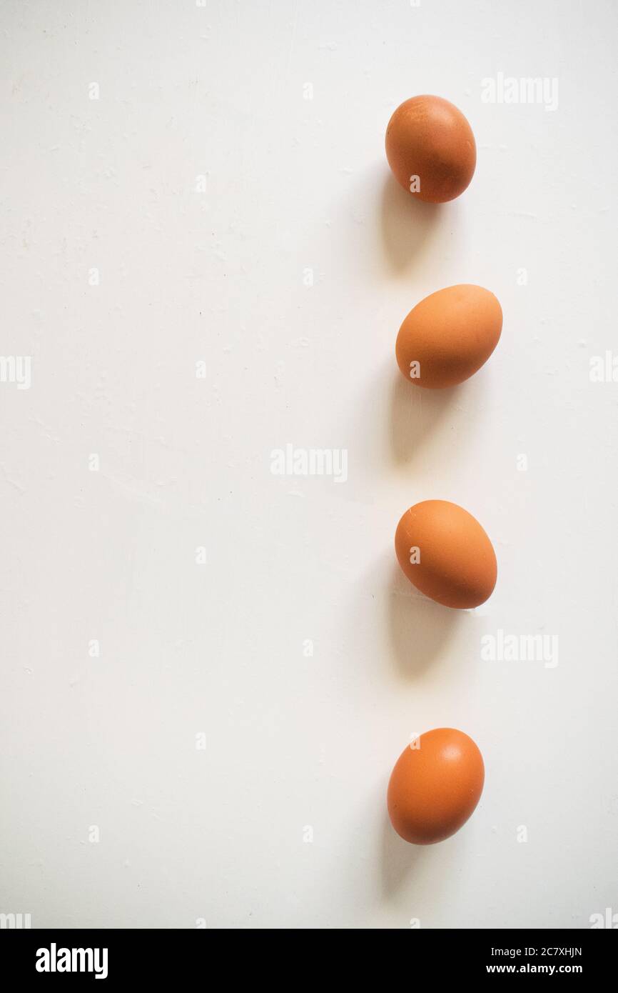 Vertical shot of four eggs in a line on a white background Stock Photo