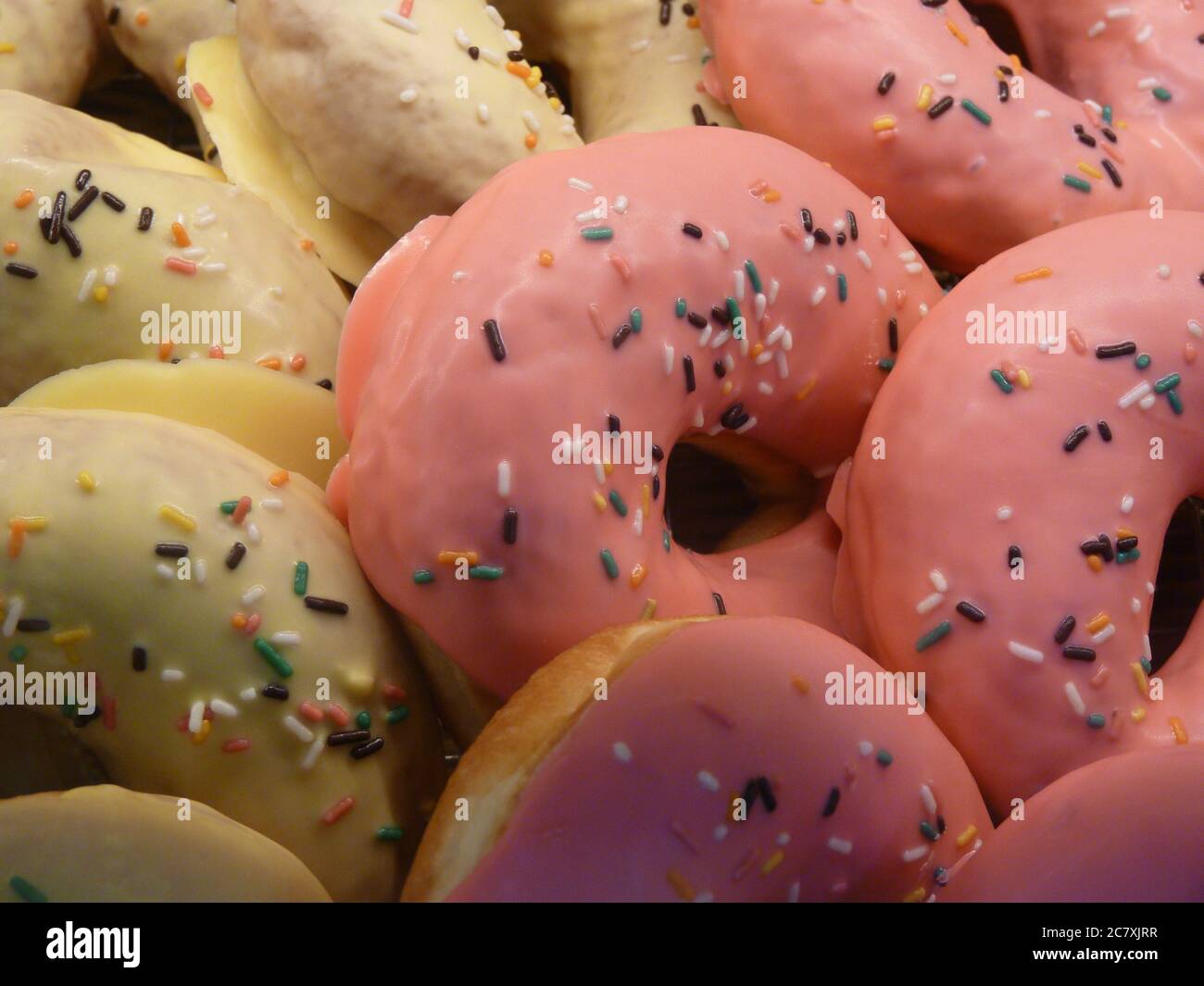 Closeup shot of freshly baked doughnuts with white and pink cream Stock ...