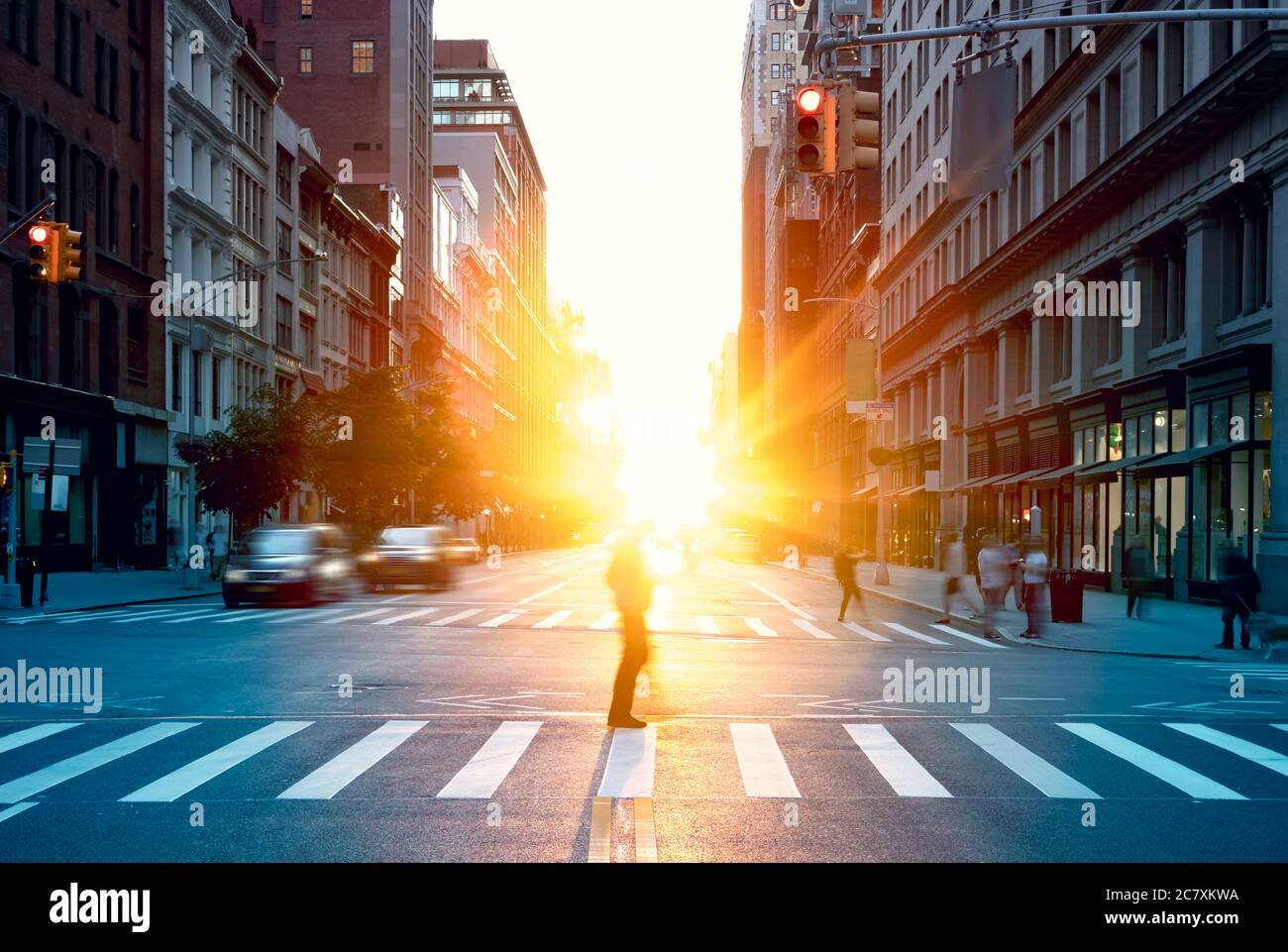 Blurred image of a man walking across the street in New York City with ...