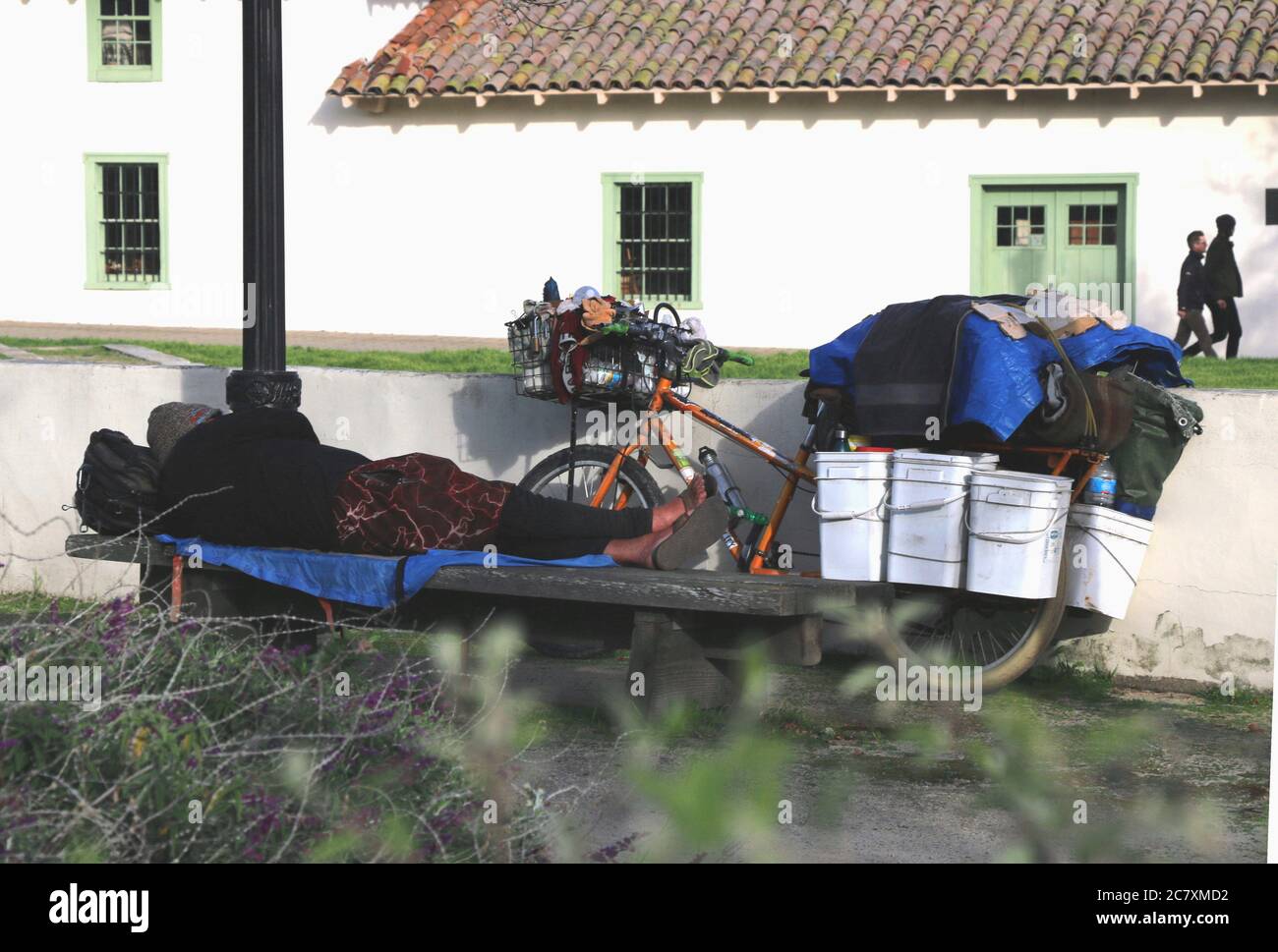 Homeless woman sleeps on a park bench during the COVID-19 pandemic, Monterey CA. Editorial. Stock Photo