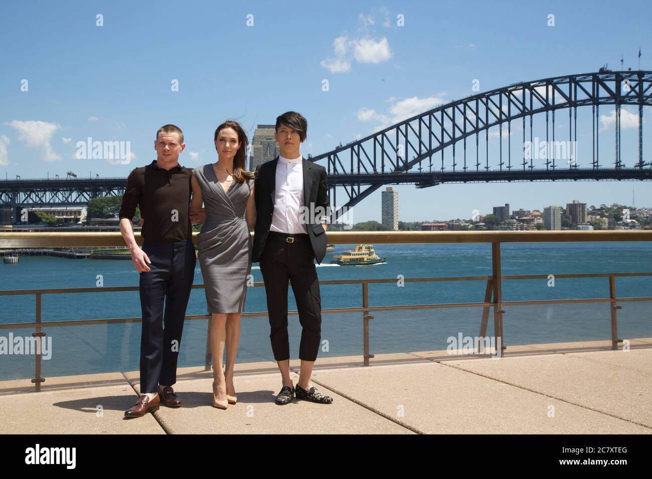 Unbroken producer and director Angelina Jolie with actors Jack O’Connell (Left) and Takamasa Ishihara (Miyavi) (right) in front of the Sydney Harbour Stock Photo