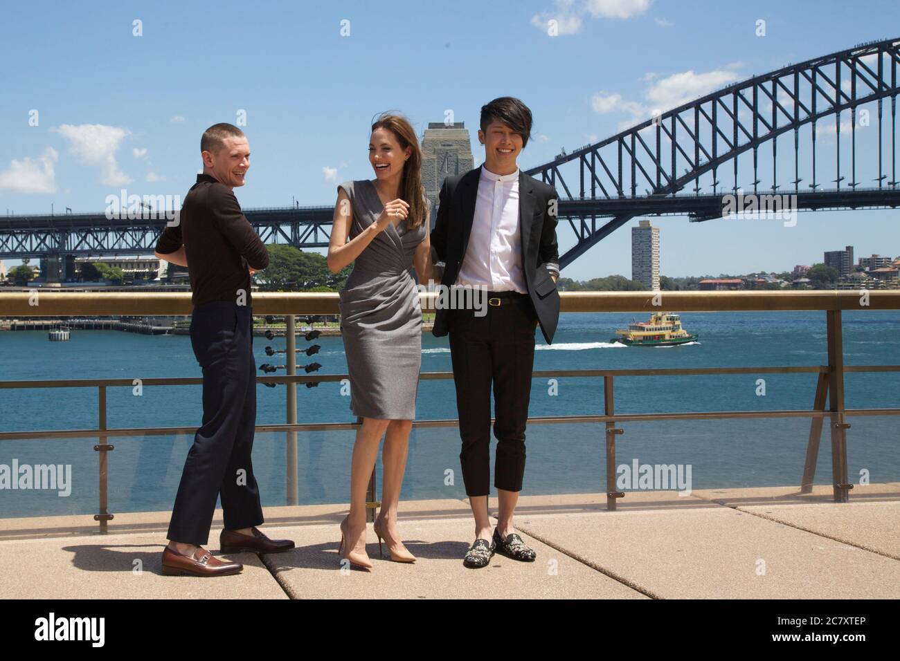 Unbroken producer and director Angelina Jolie with actors Jack O’Connell (Left) and Takamasa Ishihara (Miyavi) (right) in front of the Sydney Harbour Stock Photo