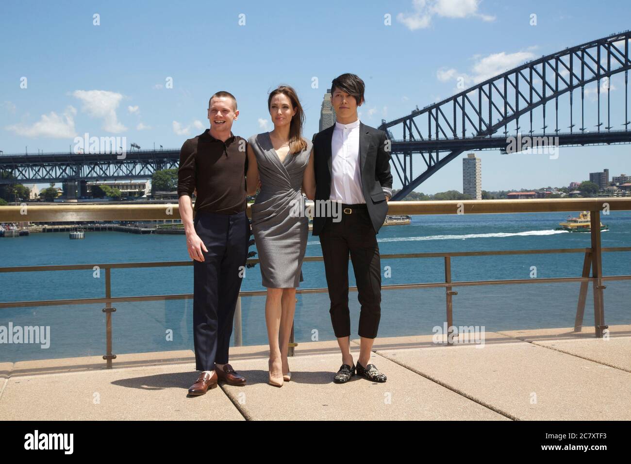 Unbroken producer and director Angelina Jolie with actors Jack O’Connell (Left) and Takamasa Ishihara (Miyavi) (right) in front of the Sydney Harbour Stock Photo