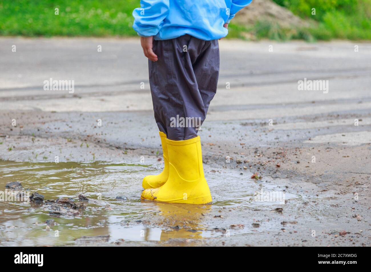 Feet of child in yellow rubber boots jumping over puddle in rain Stock ...
