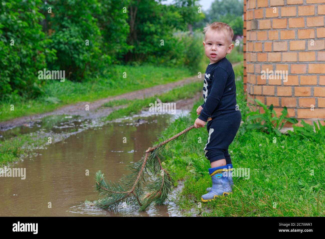 .Child in rubber boots playing in a puddle Stock Photo - Alamy