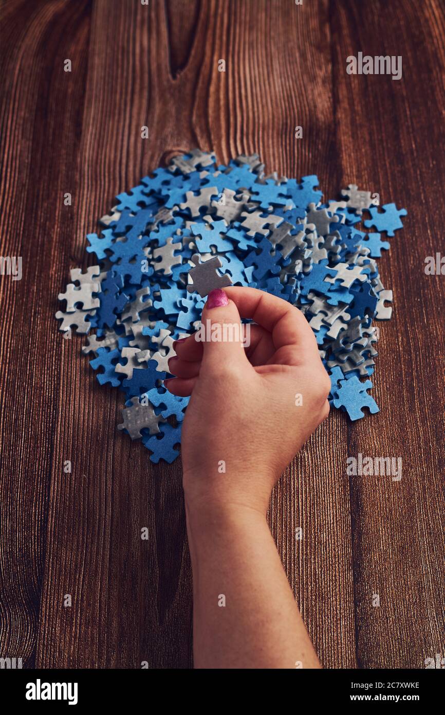 Woman collecting the small pieces of a puzzle - the concept of problem ...