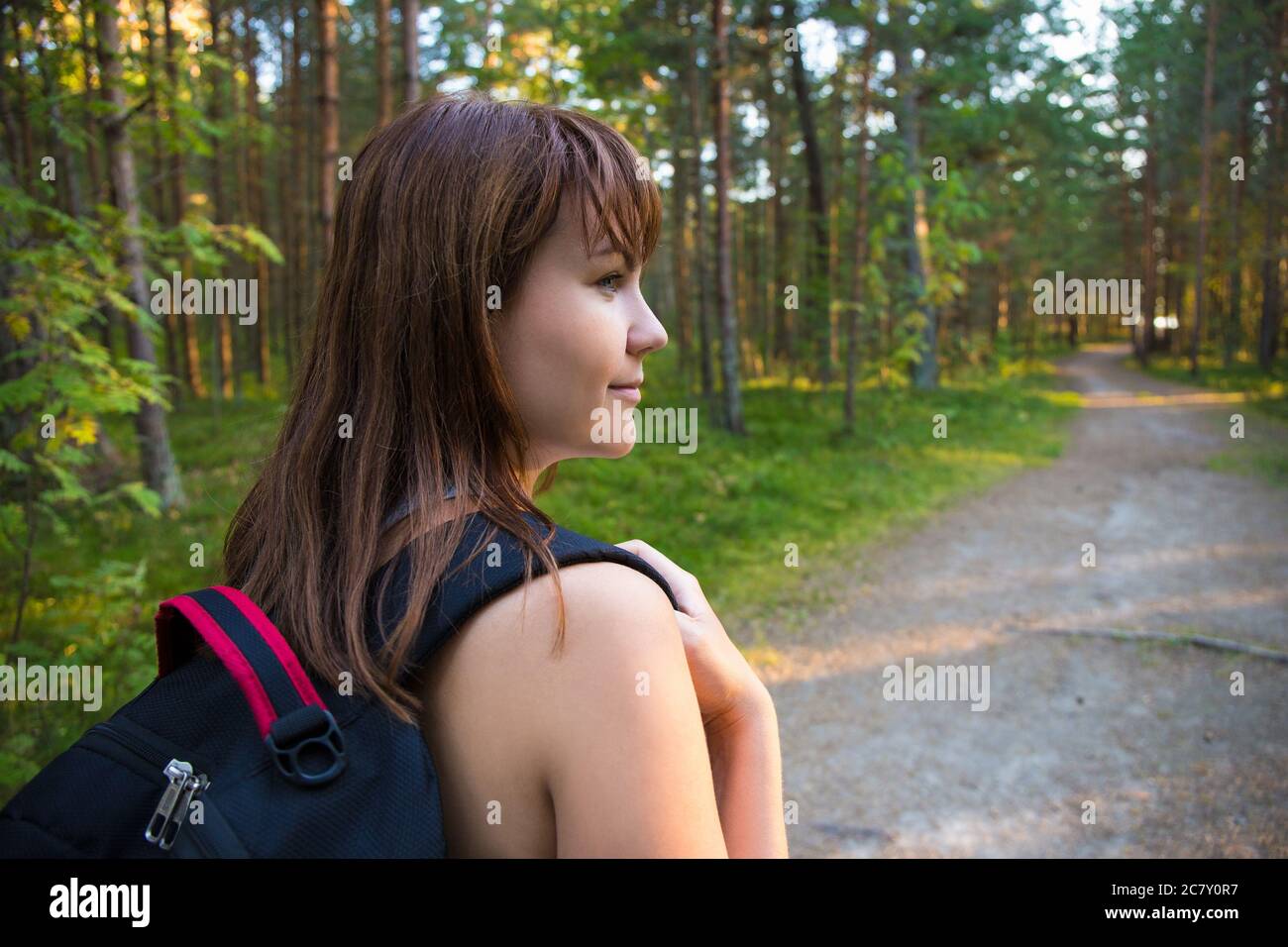 travel concept - back view of woman with backpack hiking in forest ...