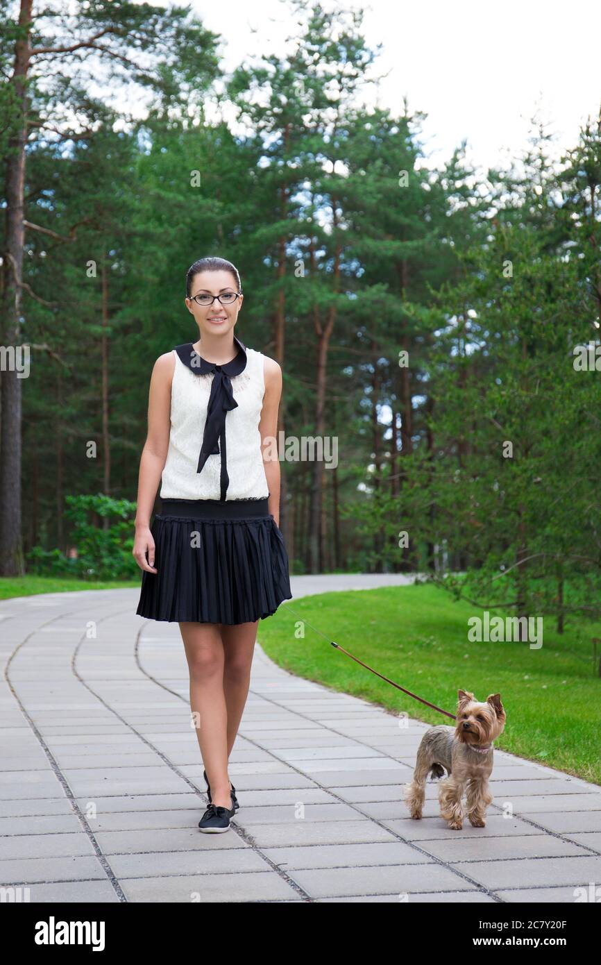 teenage girl in school uniform walking with dog yorkshire terrier in summer  park Stock Photo - Alamy