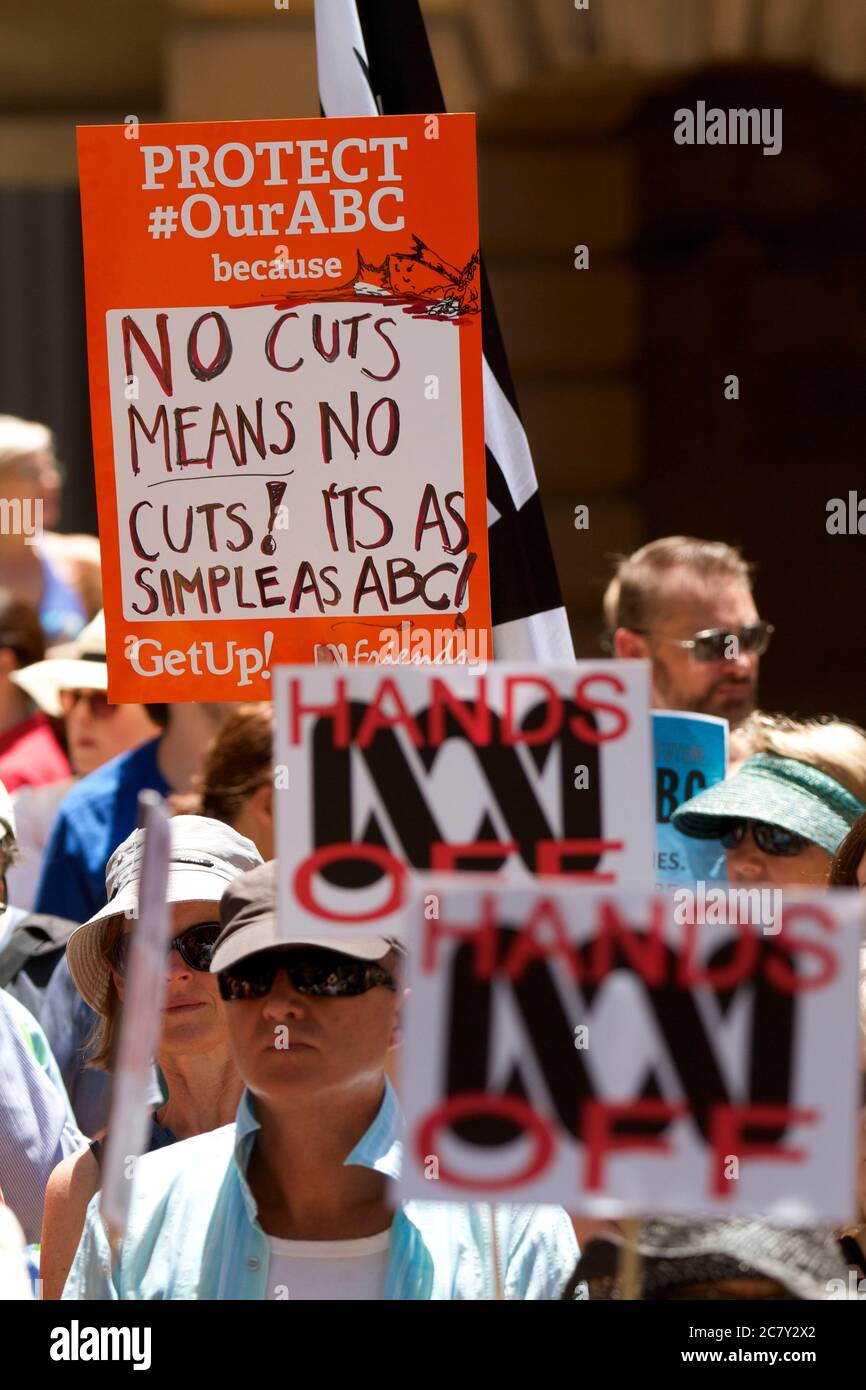 Protesters hold signs against cuts to the ABC as speakers address a ...