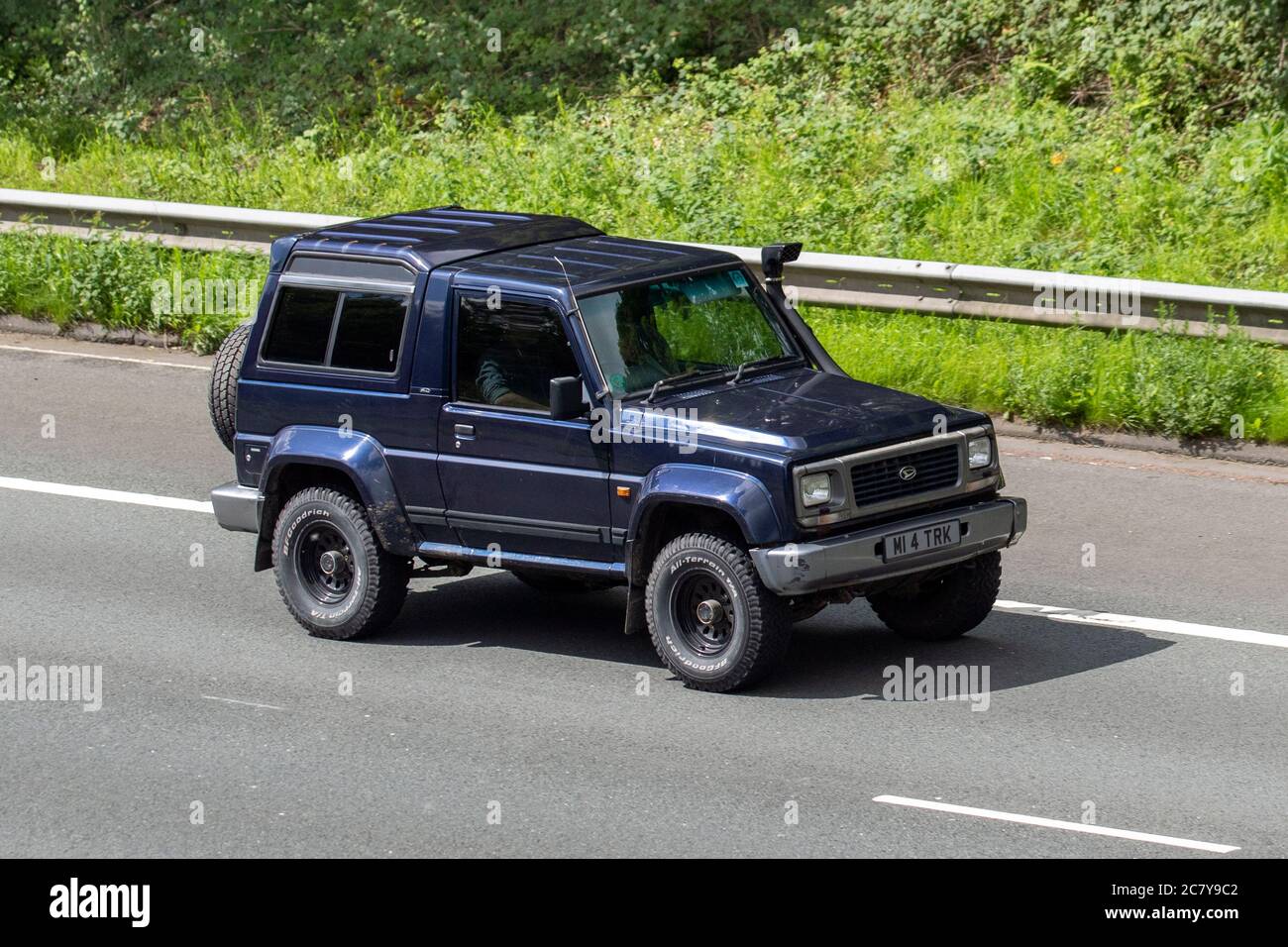 1996 90s blue Daihatsu Fourtrak IND TDX SE; Vehicular traffic moving vehicles, number plate spacing rules, illegal spacing on number plates, illegal number plates on cars, driving vehicle on UK roads, motors, motoring on the M6 motorway highway network. Stock Photo
