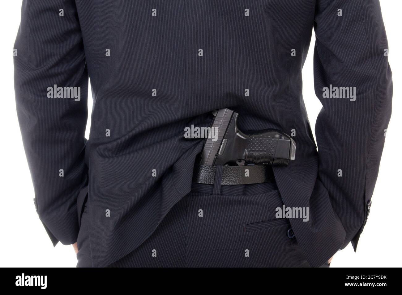 man concealing gun in pants behind his back isolated on white