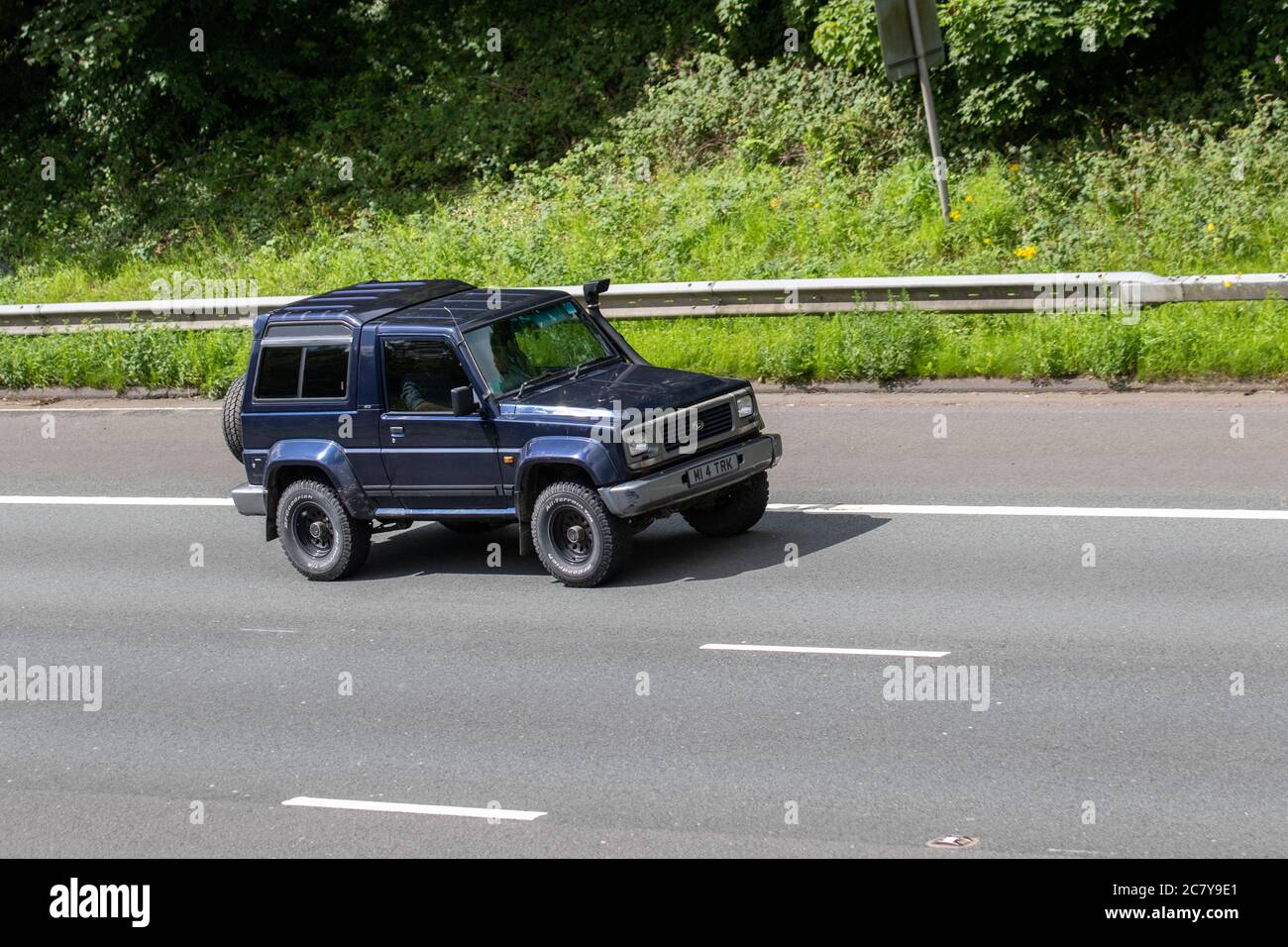 1996 blue Daihatsu Fourtrak IND TDX SE; Vehicular traffic moving vehicles, number plate spacing rules, illegal spacing on number plates, illegal number plates on cars, driving vehicle on UK roads, motors, motoring on the M6 motorway highway network. Stock Photo