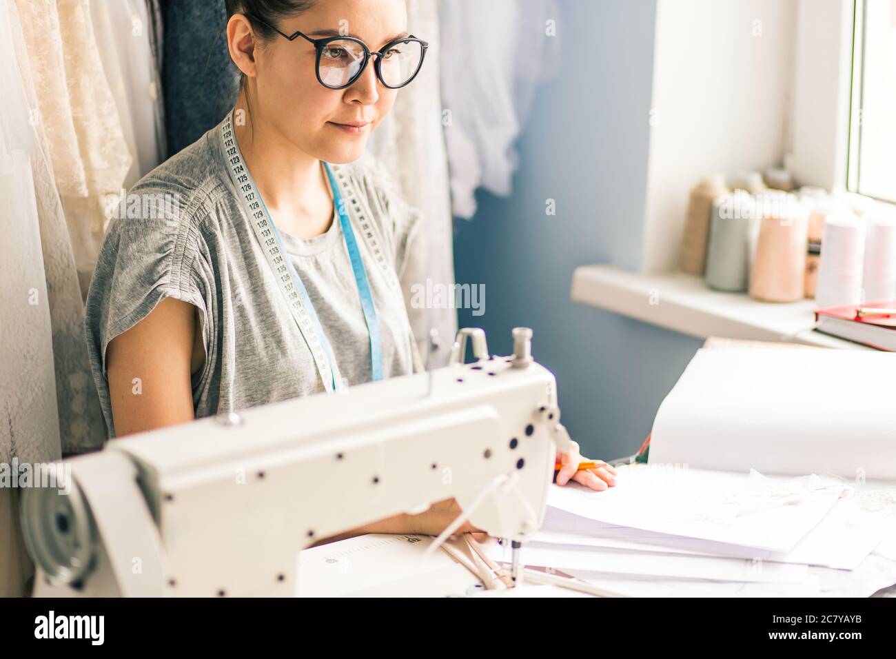 Close up. hands woman Tailor working cutting a roll of fabric on which