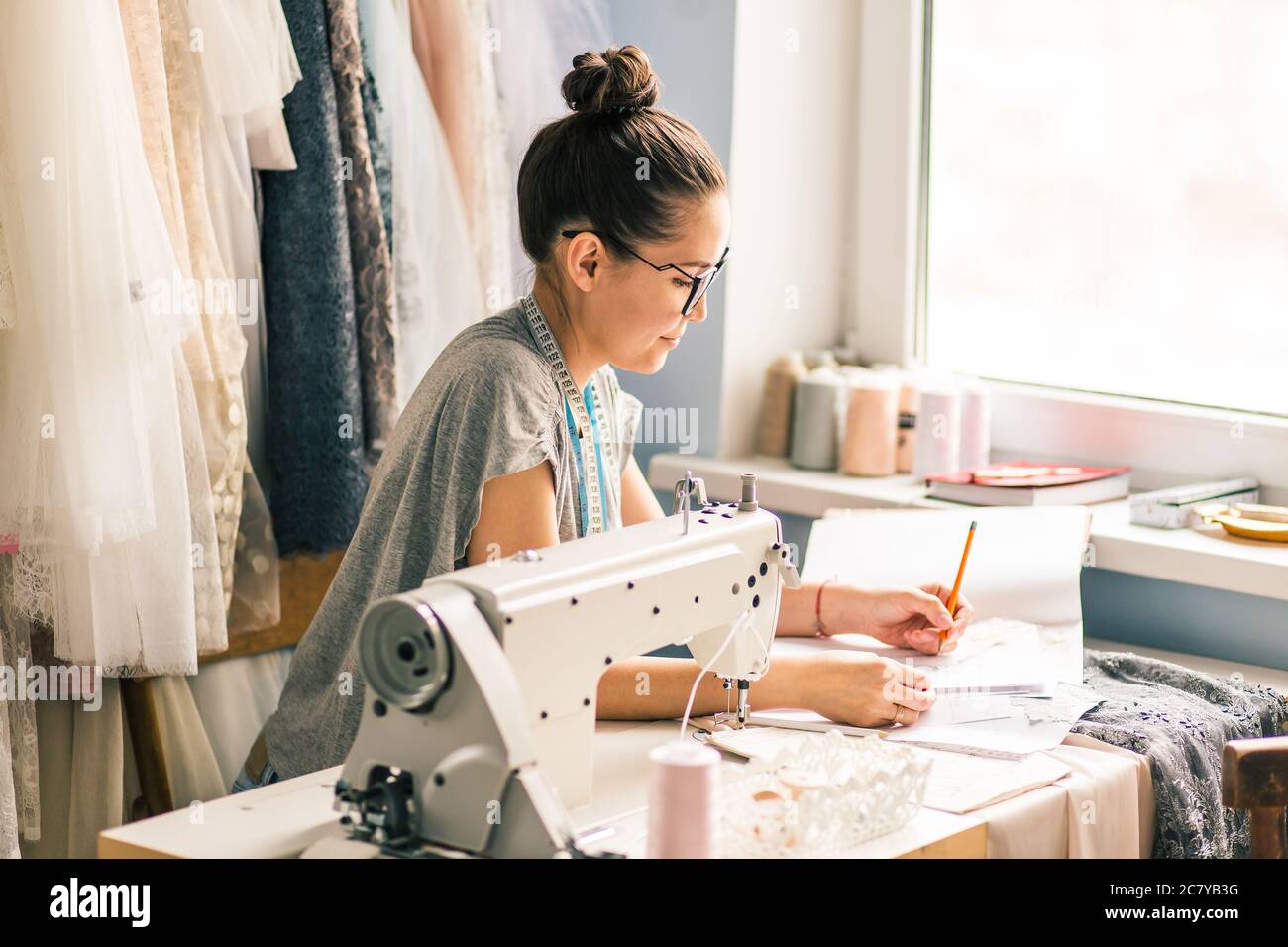 Close up. hands woman Tailor working cutting a roll of fabric on which