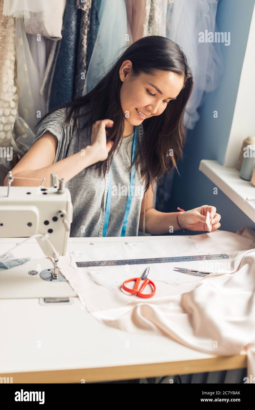 Close up. hands woman Tailor working cutting a roll of fabric on which