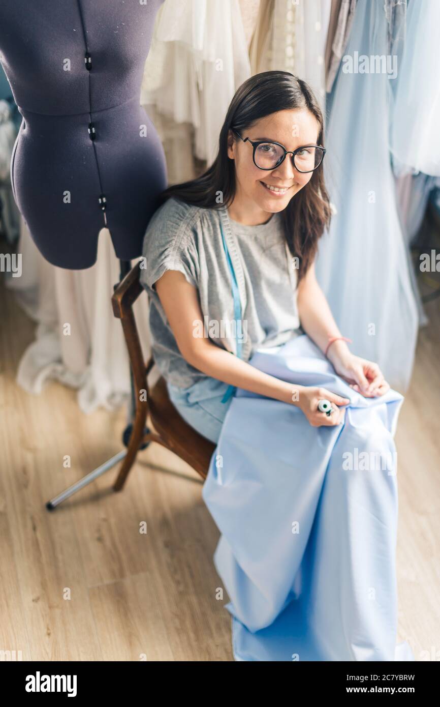 Seamstress unrips fabric near sewingmachine Stock Photo Alamy