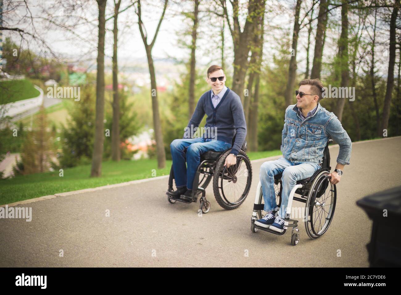 Shot of a young man spending time in a park with his friend using a ...
