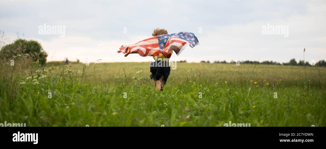 Patriotic holiday. Happy kid, cute little child girl with American flag. Stock Photo