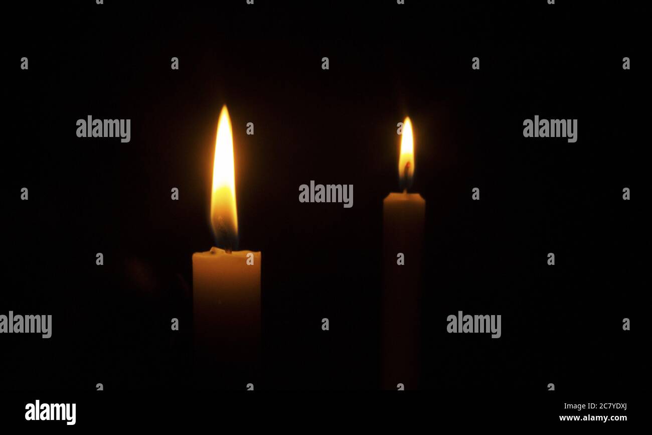 Burning candles on a black background Stock Photo - Alamy