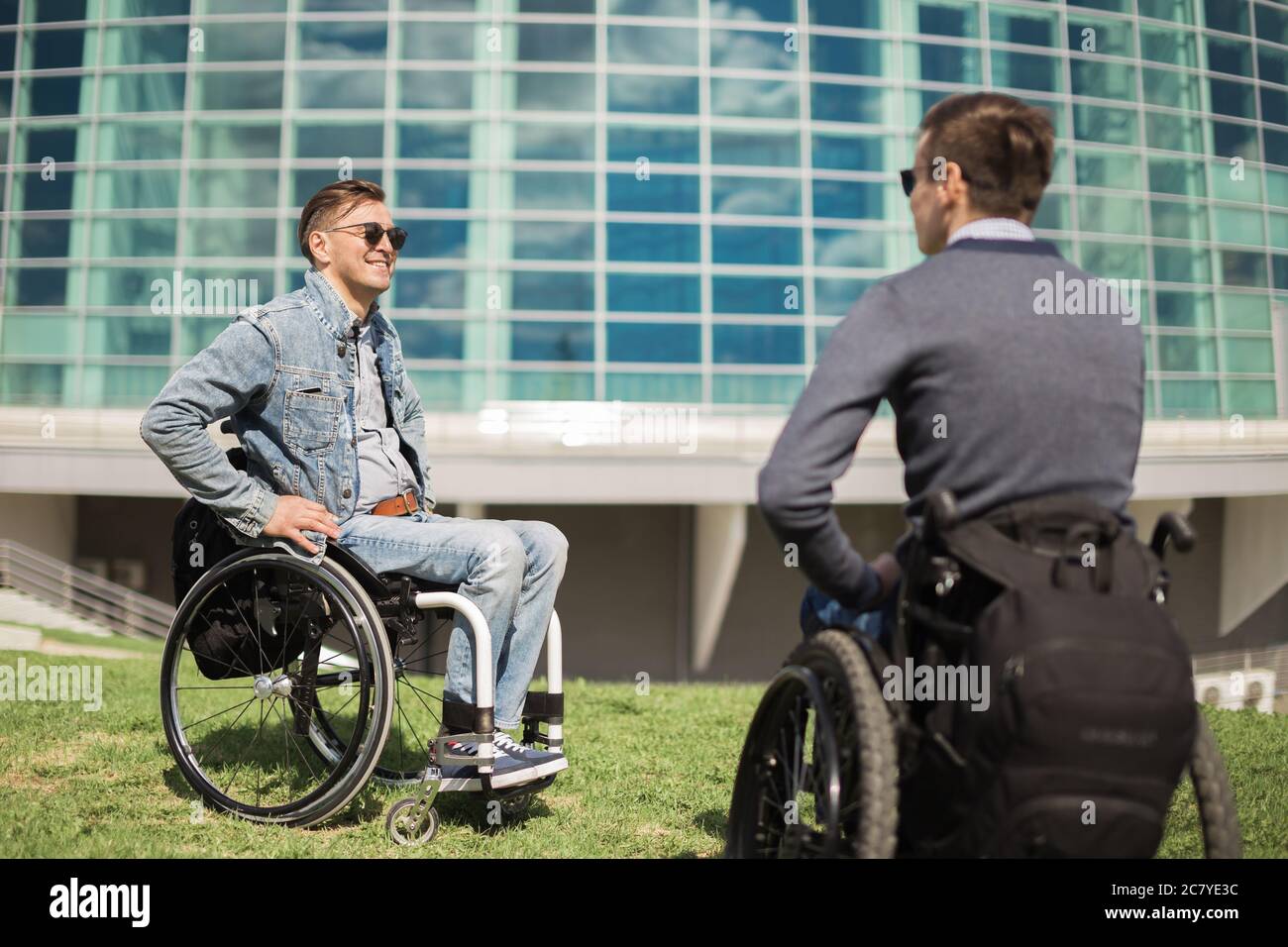 Shot of a young man spending time in a park with his friend using a ...