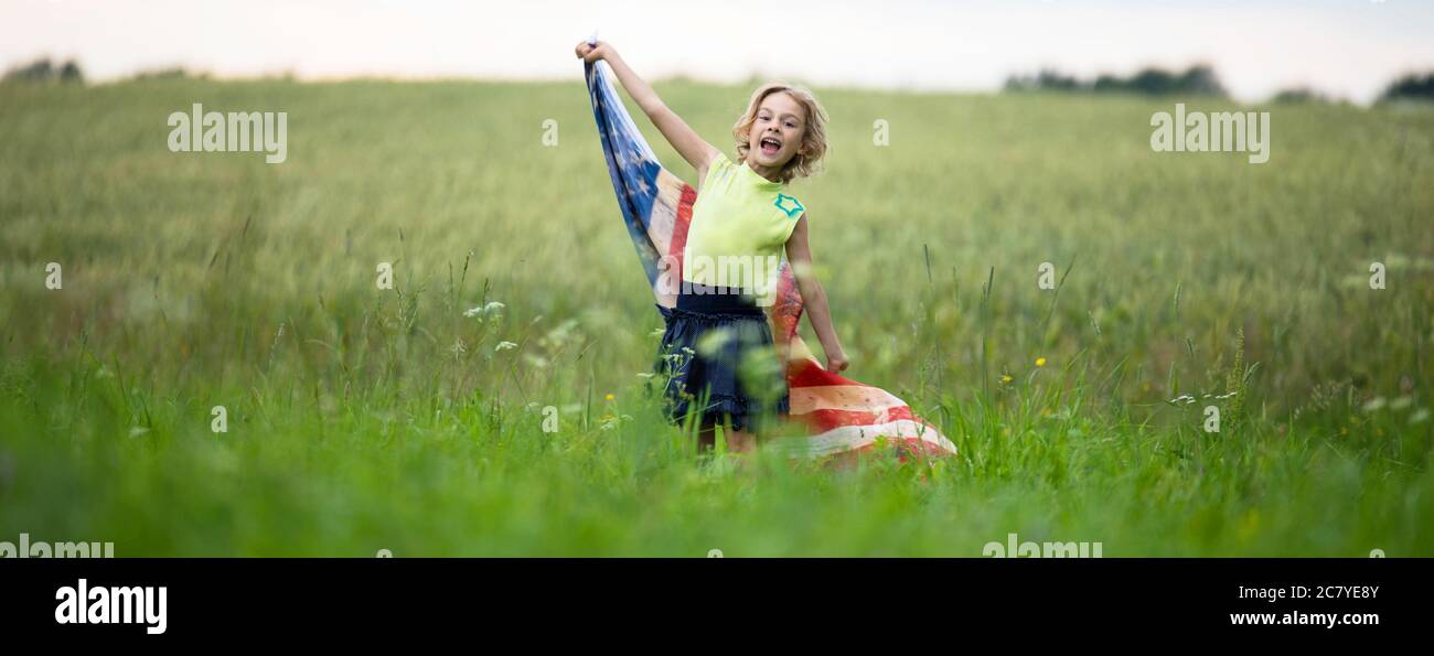 Patriotic holiday. Happy kid, cute little child girl with American flag. Stock Photo