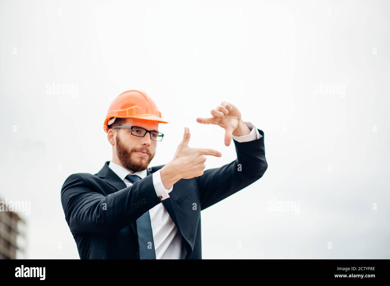 senior builder in hardhats pointing workers outdoors Stock Photo