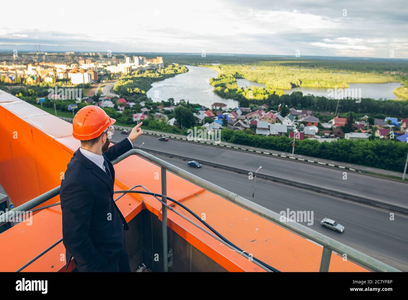 senior builder in hardhats pointing workers outdoors Stock Photo