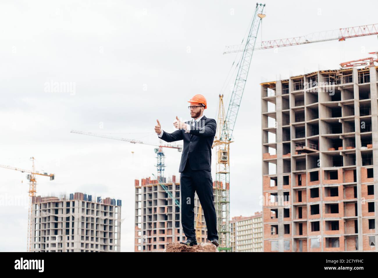 senior builder in hardhats pointing workers outdoors Stock Photo