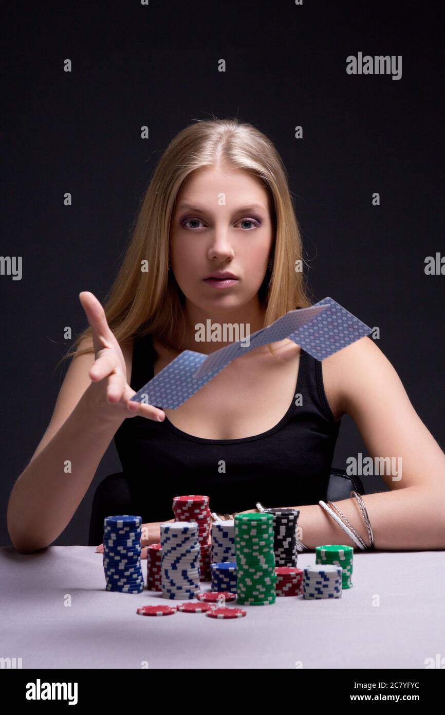 young attractive woman throwing playing cards in casino Stock Photo
