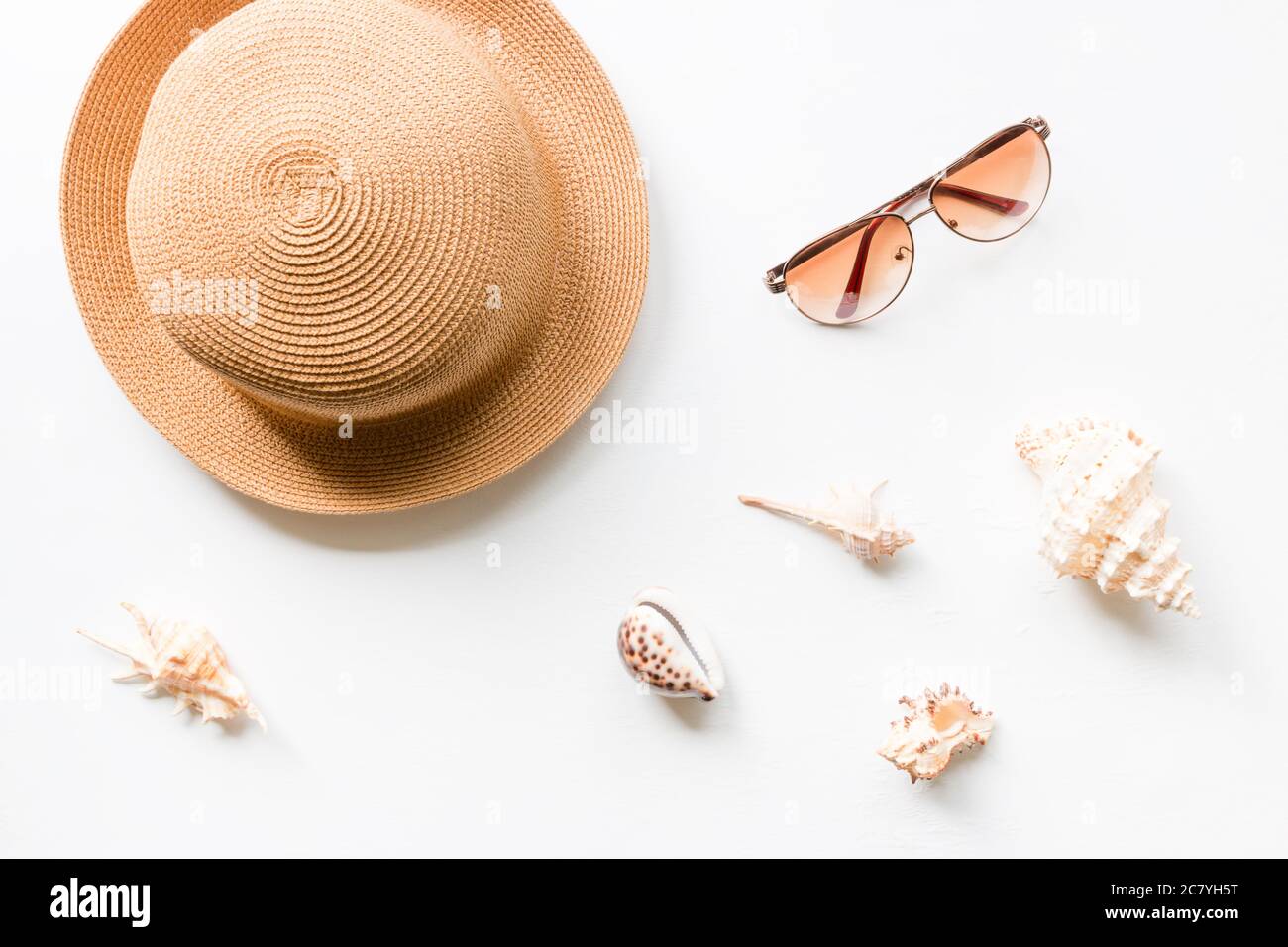 Summer straw hat beach with seashells and sunglasses on a white ...