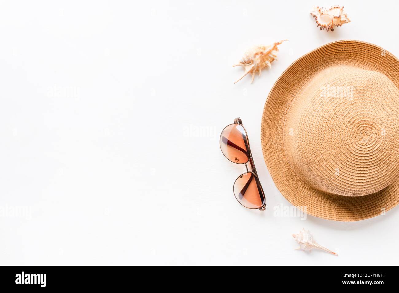 Summer straw hat beach, seashells and sunglasses on a white background ...