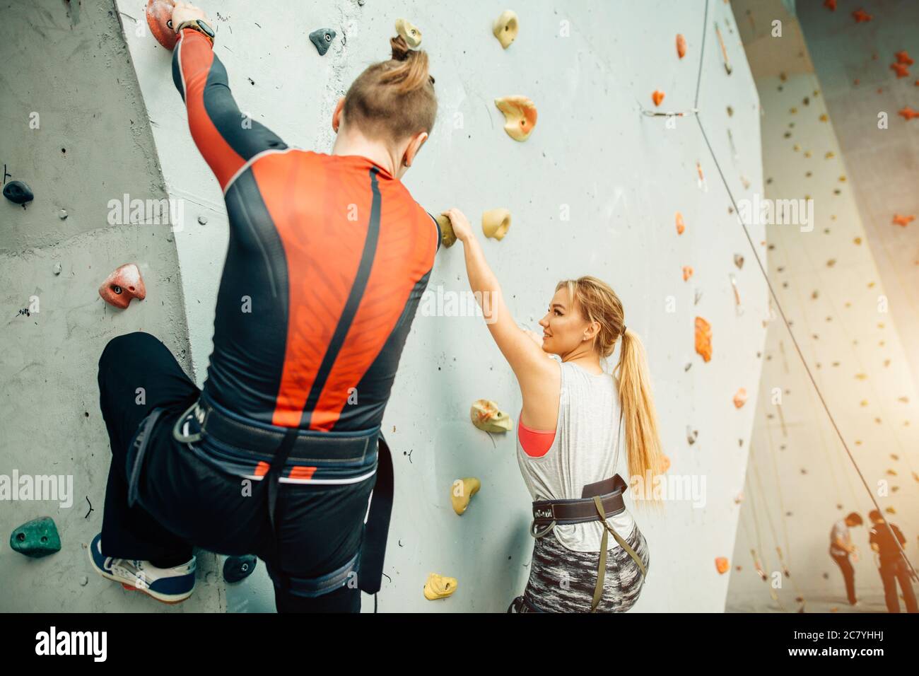 Instructor showing woman rock climbing wall at the gym Stock Photo Alamy