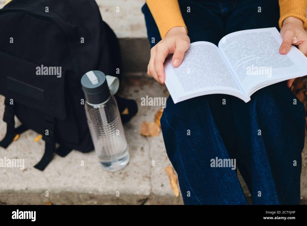 Close up student girl reading book outdoor Stock Photo - Alamy