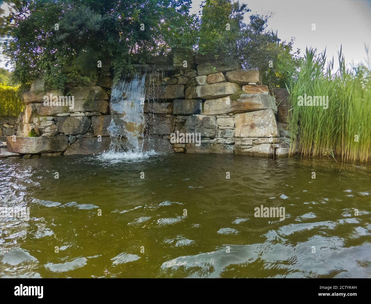 Künstlich angelegter Wasserfall in einem Schwimm Biotop Stock Photo