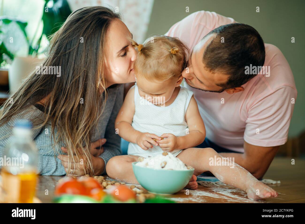 Happy parents kissing their baby in home Stock Photo