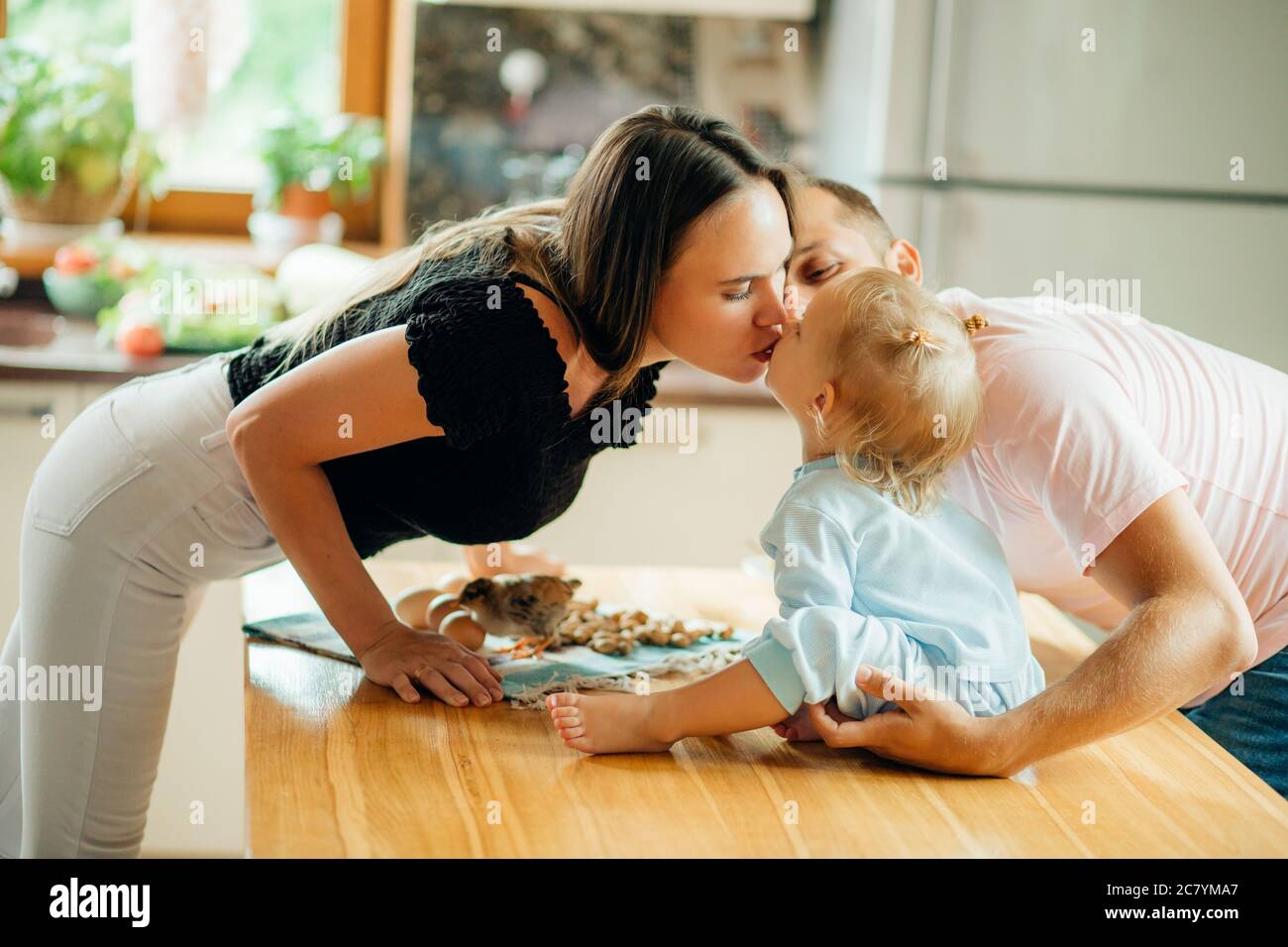 happy Parents giving their daughter a kiss. Stock Photo