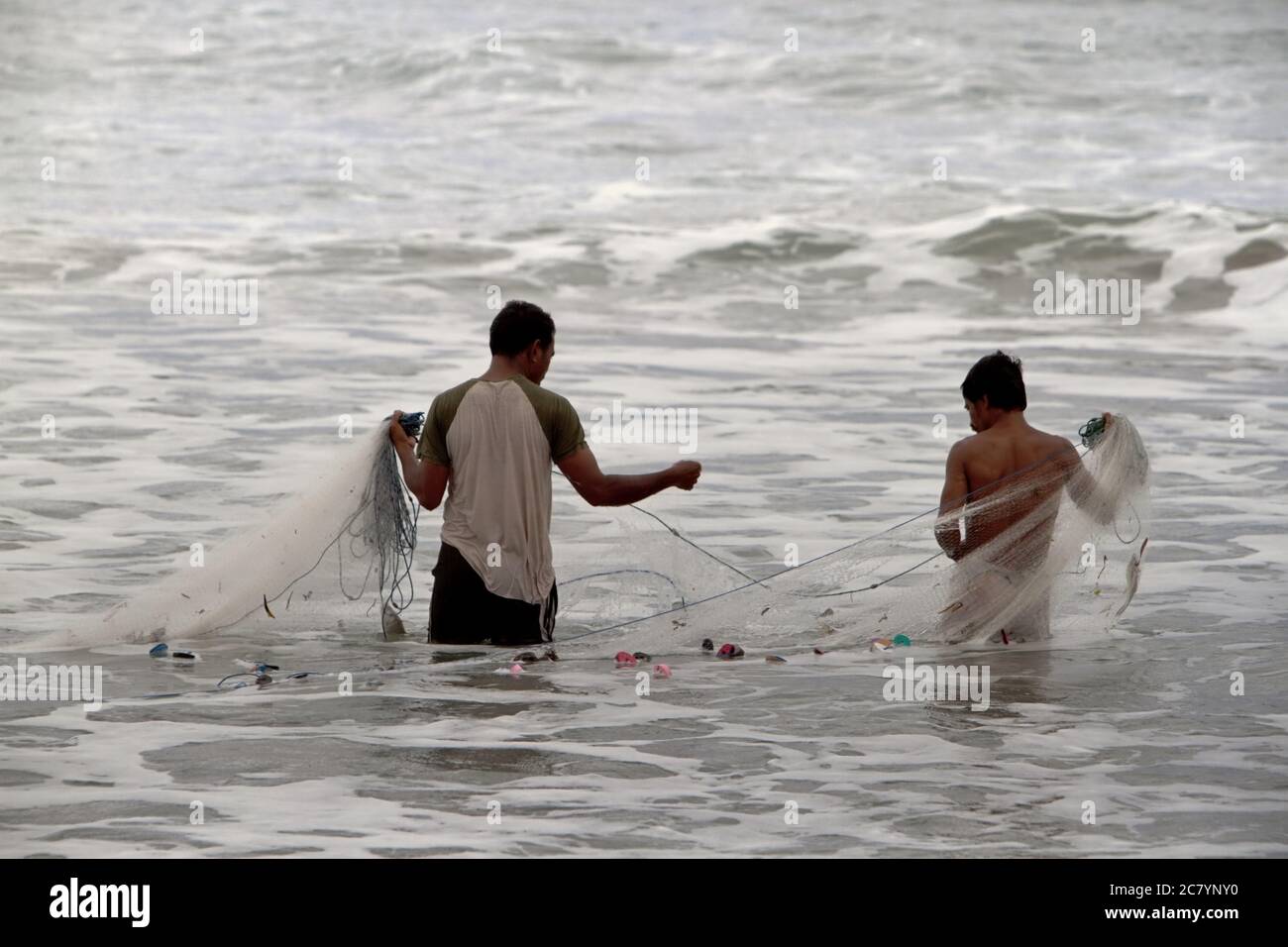 Fishermen using fishing nets on the coastal water of Kalala in Wula, Wula Waijelu, East Sumba, East Nusa Tenggara, Indonesia. Stock Photo