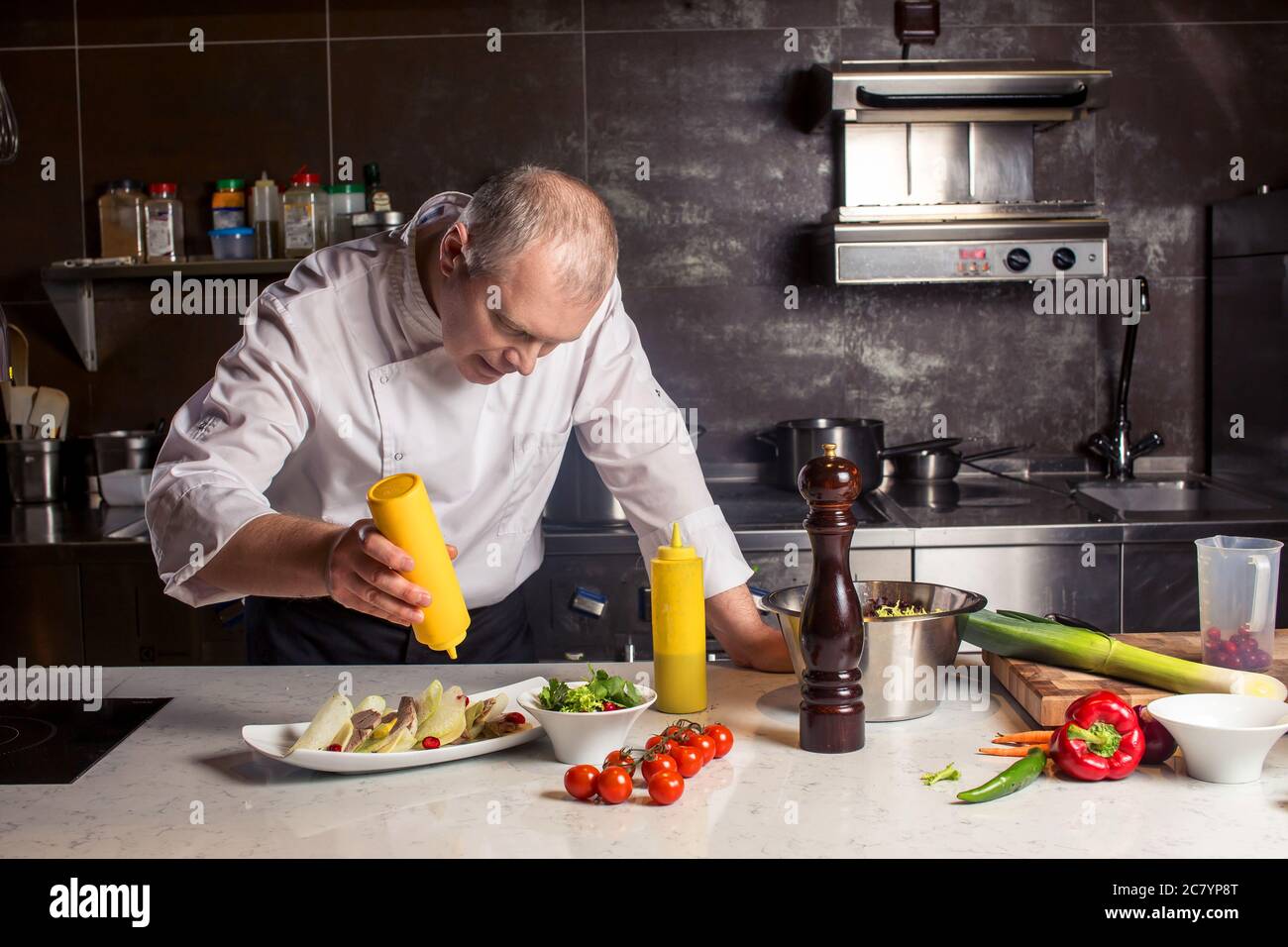 Chef in hotel or restaurant kitchen cooking, he is working on the sauce for the food as saucier