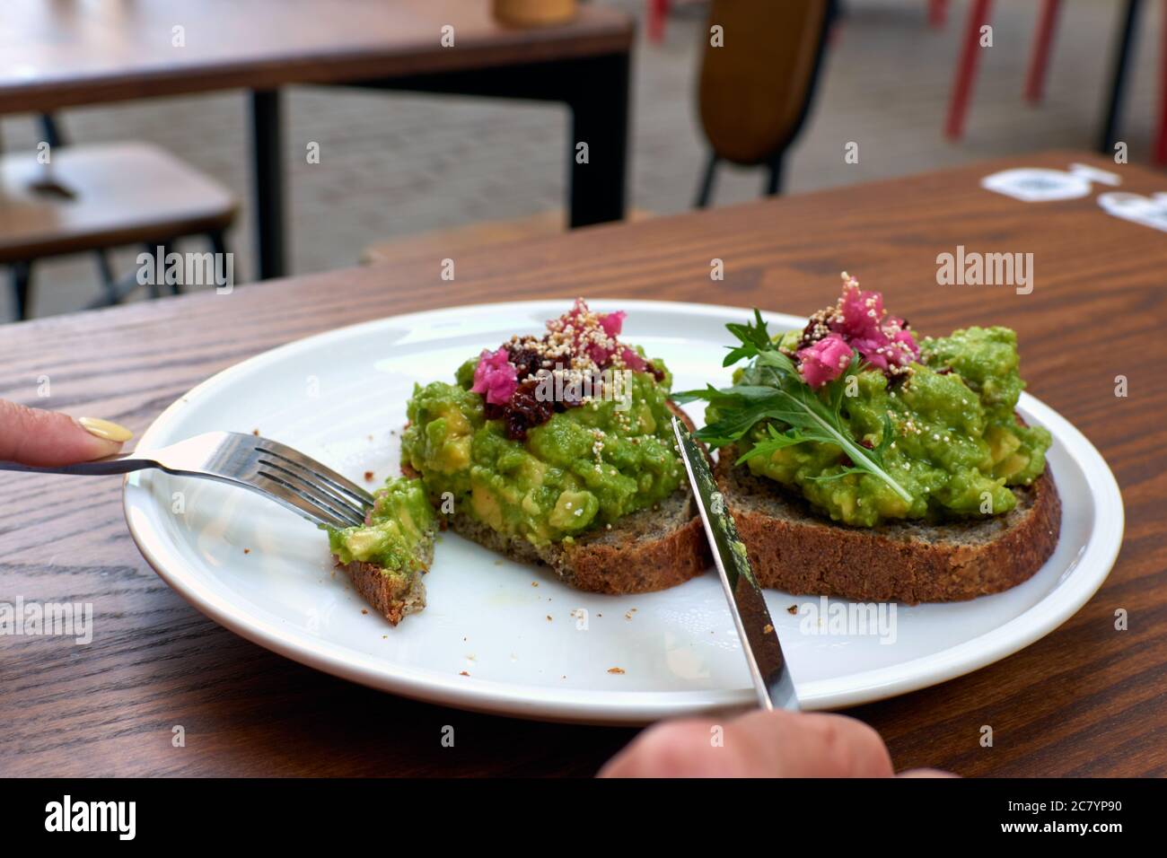 Healthy mashed avocado toasts for breakfast or lunch with rye whole grain bread, sliced avocado and sesame seeds, salt and pepper. Vegetarian. Plant Stock Photo