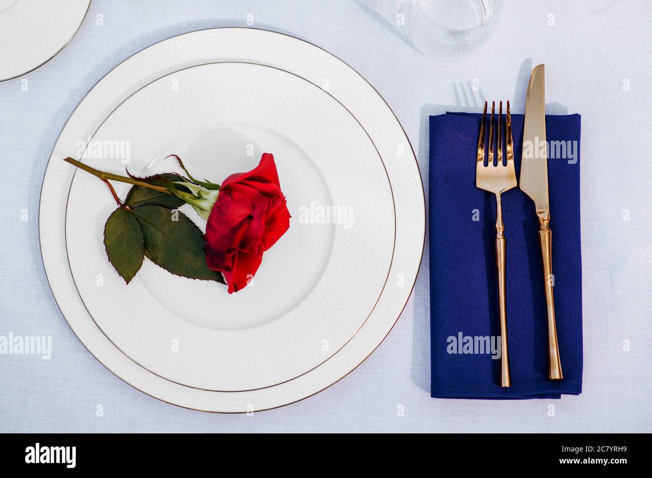 Table setting, silverware and red rose, top view Stock Photo