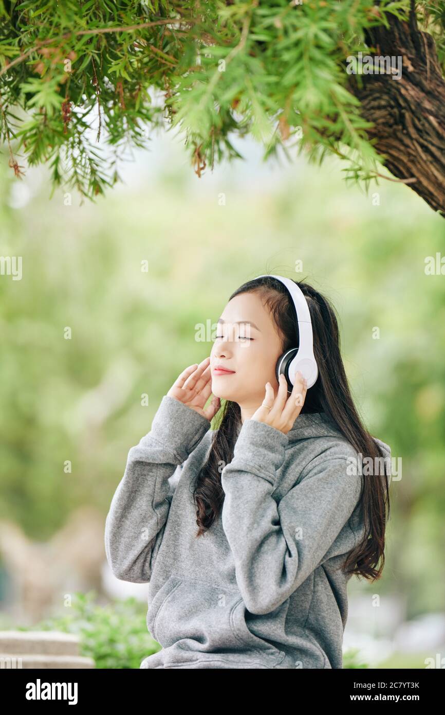 Beautiful young Vietnamese teenage girl smiling and closing eyes when