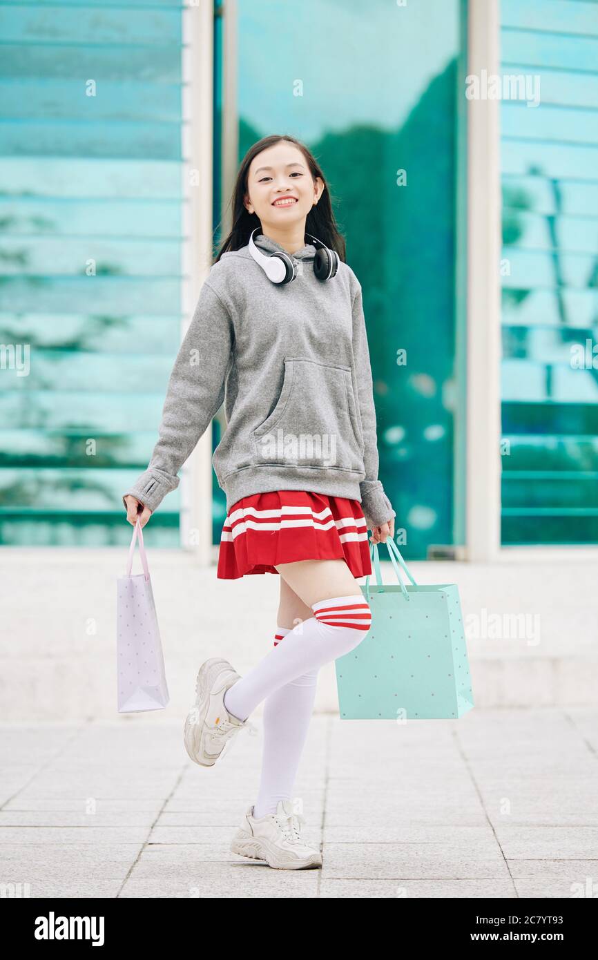 Happy excited Vietnamese teenage girl in mini skirt standing in front of  shopping mall Stock Photo - Alamy