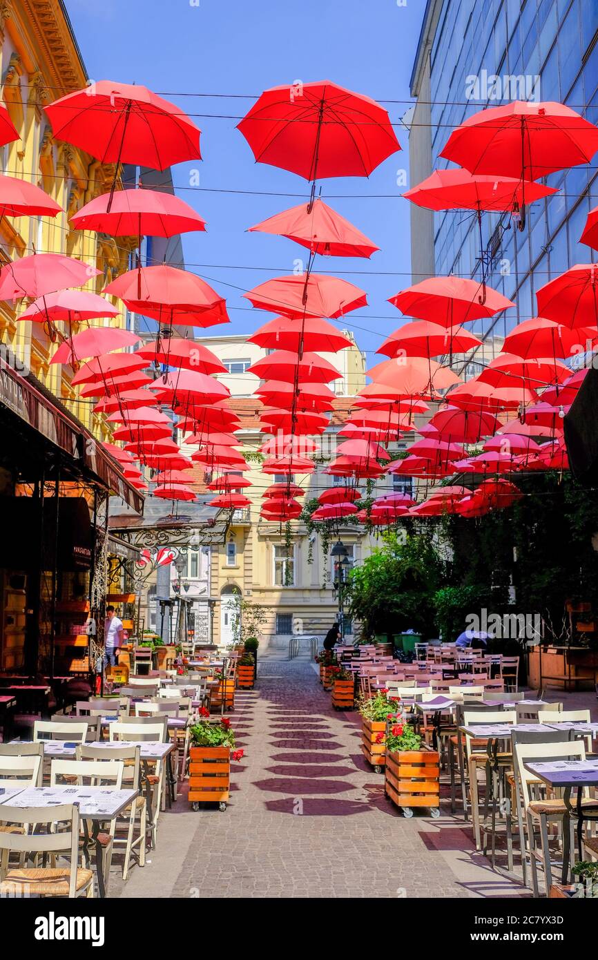 Belgrade / Serbia - May 16, 2020: Red umbrellas above the open-air restaurant in King Peter street in old bohemian part of Serbian capital Belgrade Stock Photo