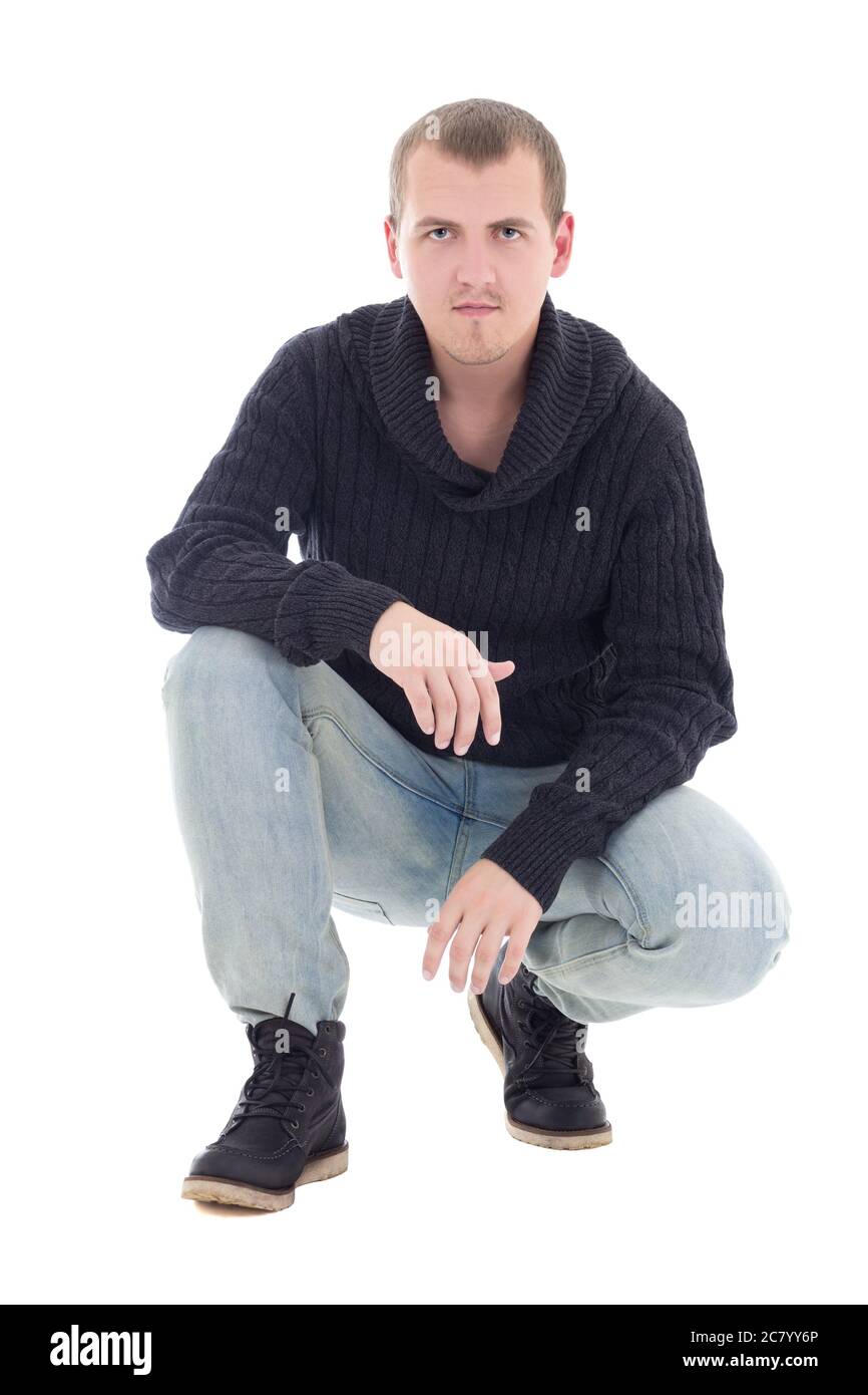 young attractive man in winter clothes sitting isolated on white ...