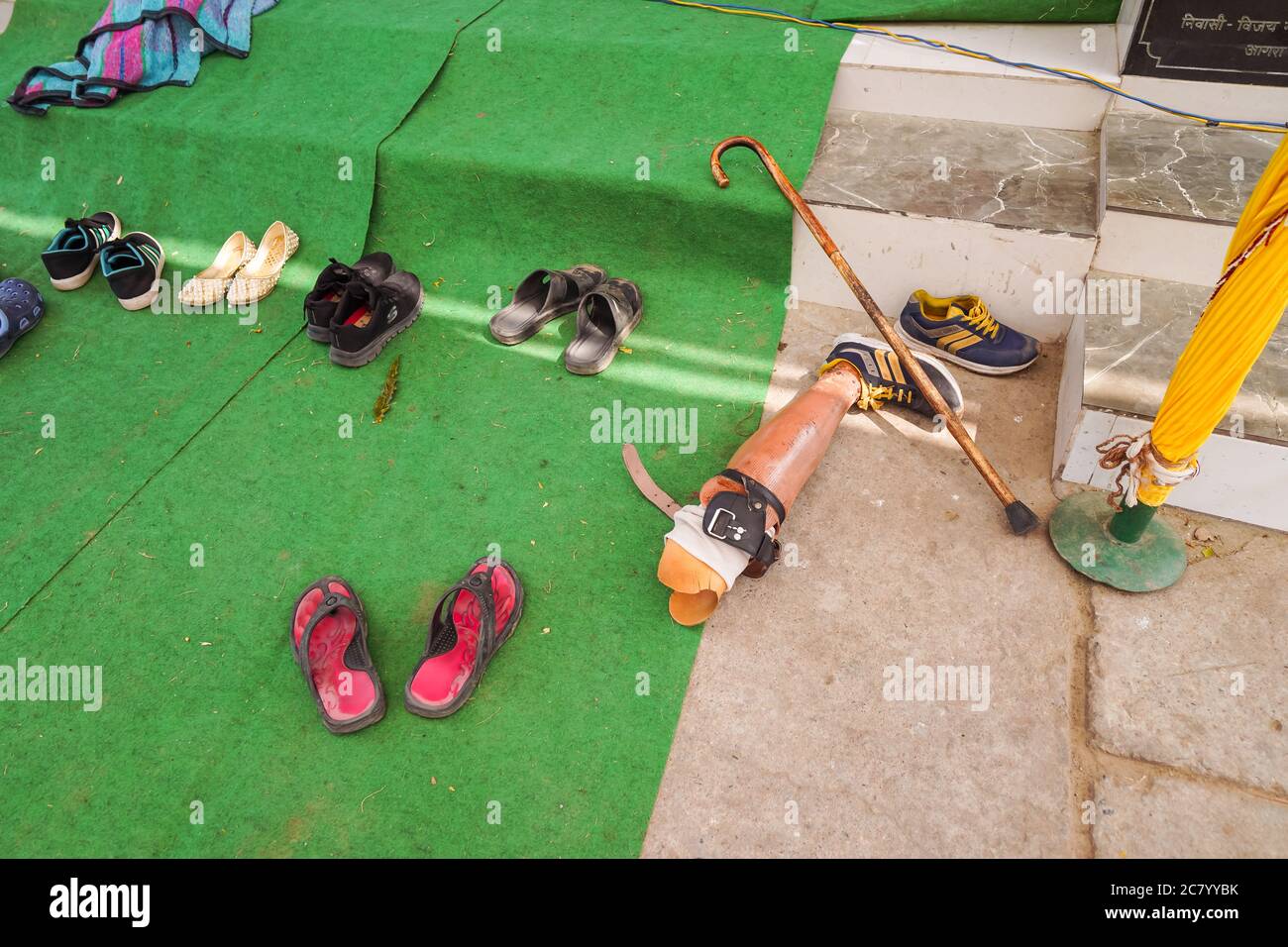 Agra / India February 13, 2020 orthopedic leg and shoes at the foot of the entrance to a