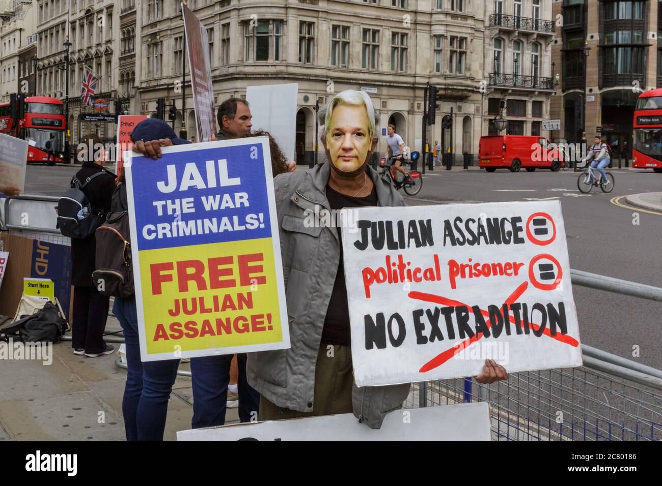 Free Julian Assange protester with placard outside Parliament in Westminster, London, UK Stock Photo