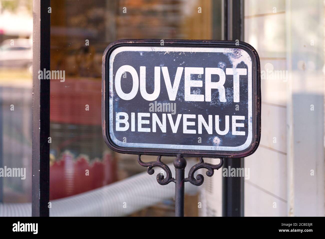 Outdoor open sign with written in it in French 'Ouvert, bienvenue' meaning in English 'Open, welcome'. Stock Photo